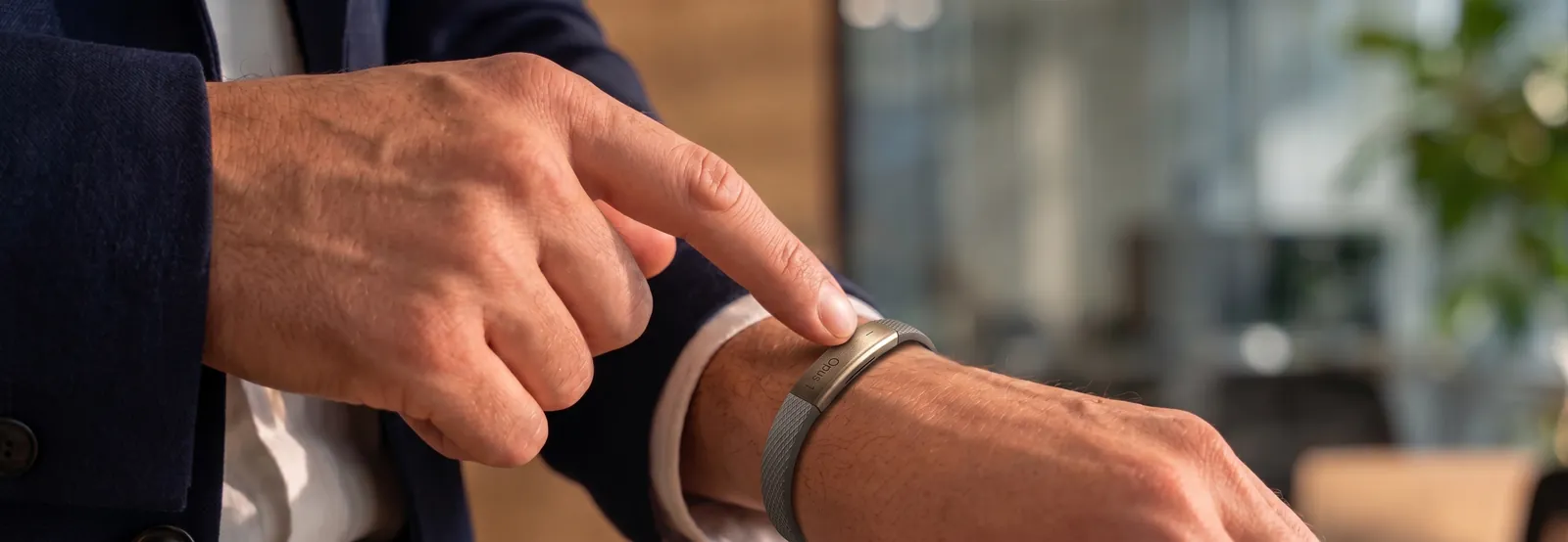 A person pressing the button on their nagome bracelet
